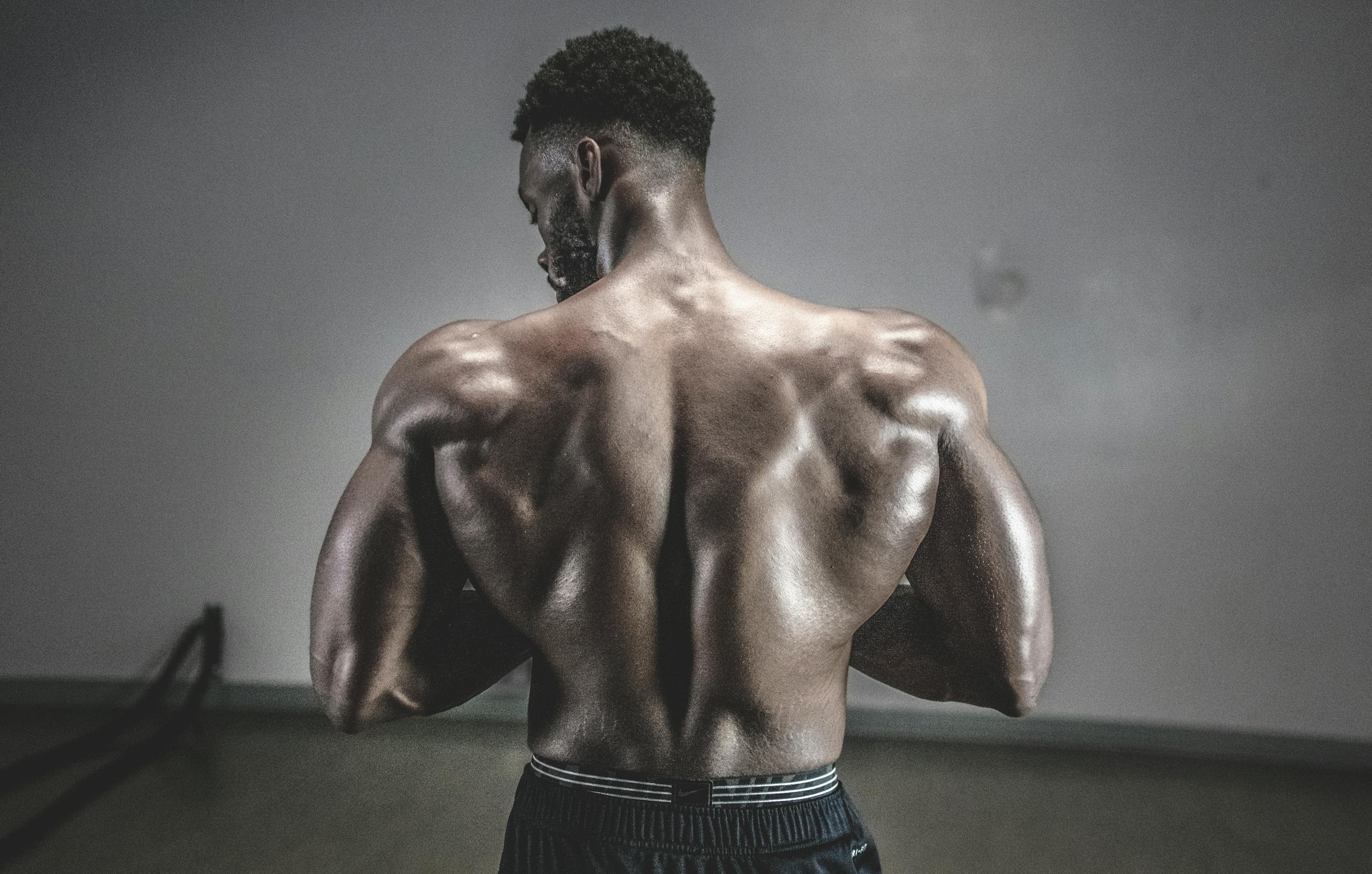 A shirtless man displaying his muscular back, showcasing strength and fitness.